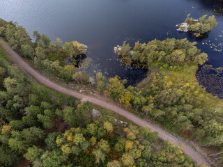 Drone nature photography taken from above in Sweden in early fall. Aerial view of a path and lake...