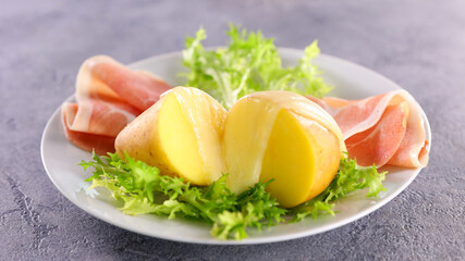 plate of potato, salami and salad with raclette cheese