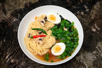 spicy chicken soup with noodles, spinach, seaweed and egg