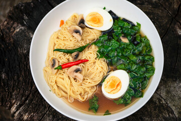 spicy chicken soup with noodles, spinach, seaweed and egg