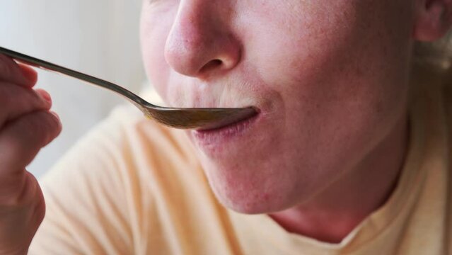 Woman eating Hungarian goulash soup close-up.