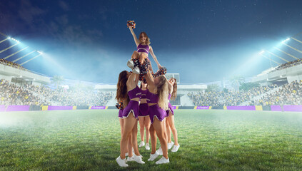 Group of cheerleaders in action on  stadium in night