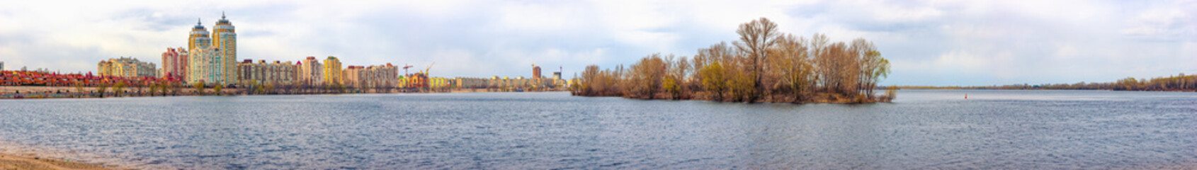 Fototapeta premium A view of the Dnieper river close to Obolonska Naberezhna in the Obolon district of Kiev, Ukraine, during a cold winter day. Buildings appear in the distance