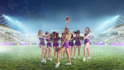 Group of cheerleaders in action on  stadium in night