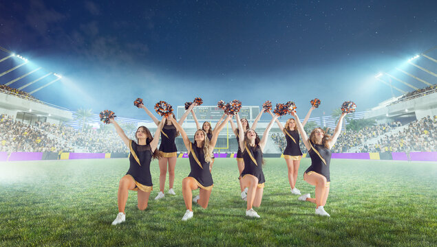 Group of cheerleaders in action on  stadium in night