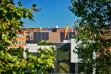 Solar panels on the roofs of houses with the flag of Spain.