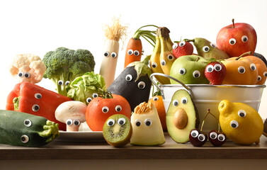 Child nutrition concept with fruits and vegetables with eyes front