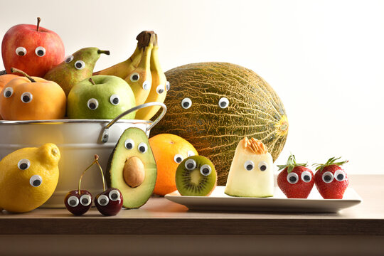 Group of fruits with eyes on wooden kitchen bench