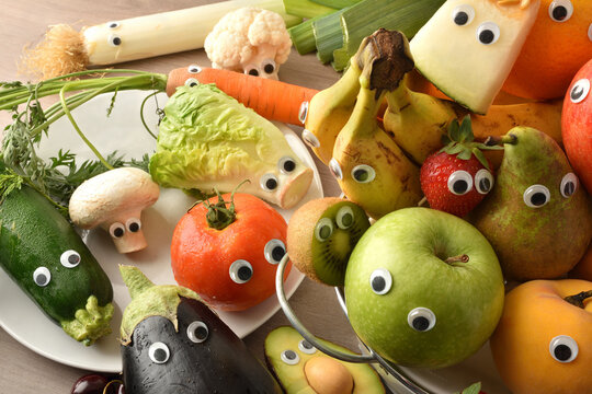 Child nutrition concept with fruits and vegetables with eyes top