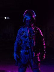 Army soldier in Combat Uniforms with an assault rifle and combat helmet night mission dark...