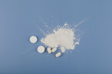 Titanium dioxide, TiO2. Food additive E171. White chemical powder, chewing gum and pills on blue....