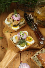 Sandwiches with canned pike and egg on a wooden table