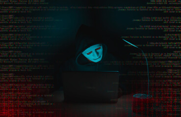 A hacker in black uses a laptop on a desk to hack a system with binary code.Cyber attack, system...