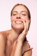 Half-legnth portrait of smiling beautiful girl with naked shoulders applying eye patches isolated over white background