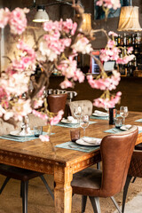 Bonito interior de restaurante con árbol cerezo. Mesa de madera. 