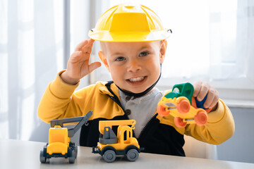 Plakat Child play with construction machinery at home, dreams to be an engineer. Little builder. Education, and imagination, purposefulness concept. Boy with digger
