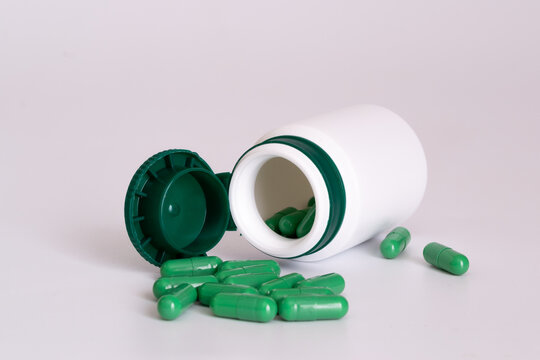 Green Pills With Pill Bottle On White Background With Space For Text