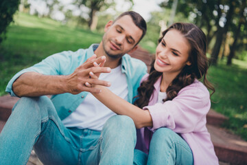 Fototapeta premium Portrait of two lovely peaceful people sitting stairs hold touch tender hands spend pastime together outside