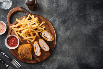 Cordon bleu and french fries. Chicken cordon bleu schnitzel, meat wrapped around ham and cheese, breaded and fried - 532443931