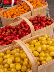 baskets of colorful orange, red and yellow grape tomatoes