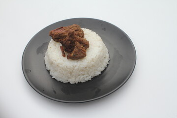 a plate of rice and beef rendang