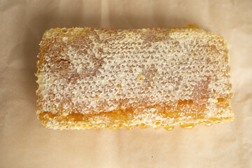 honeycombs with honey close-up, on craft paper, on the table, in the room. Collection of honey. Natural sweets, treatment of angina and SARS