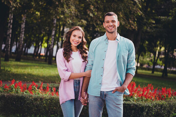 Photo of positive attractive lady handsome man hold arms spend pastime date park outside