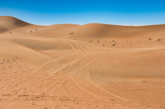 Landscape photo of desert and sand dune under the clear blue sky in Dubai, UAE