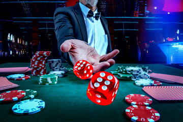 Gambling concept. Close up of male hand throwing dice at casino, gambling club. Сasino chips or...