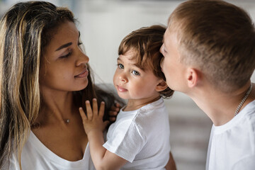 a friendly happy family, parents playing with a small child.