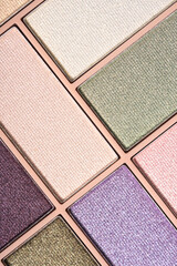 Fototapeta premium Glitter eyeshadows palette for festive makeup as background. Professional make up and beauty concept, flat lay. Vertical image