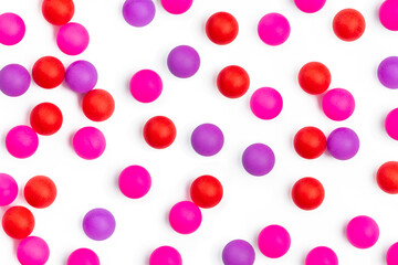 Abstract colored balls background. Red, pink taw toy scattered on isolated white background. Base for design nice backdrop, wallpaper, poster