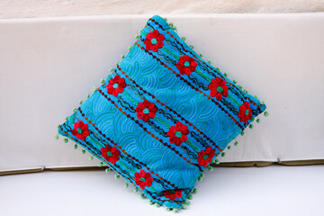 Blue cushion with red flower pattern
