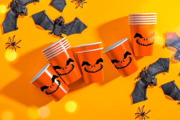 Halloween party background with Paper cup with Jack lantern face decoration. Disposable cup made of recycled paper orange colors. Pattern for outumn october holiday all saints day celebration