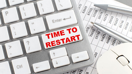 TIME TO RESTART text on keyboard wirh chart and pencil