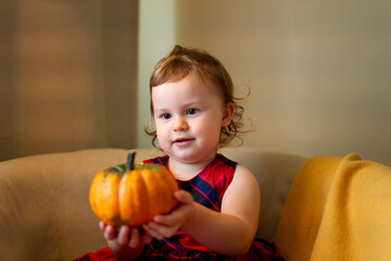 Fototapeta na wymiar happy baby with a pumpkin for Halloween home