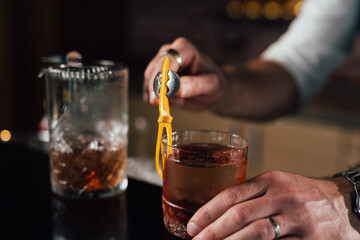 close up of barman decorate negro martini cocktail