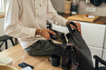 young businessman pack his business bag for work