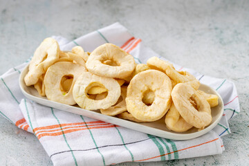 Dried apple slice on gray background. Dried fruit in sunlight. close up