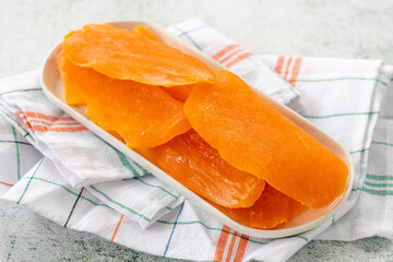 Dried mango slice on gray background. Dried fruit in sunlight. close up