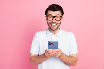 Photo of positive nice man dressed trendy outfit use telephone enjoy modern device gadget isolated on pink color background