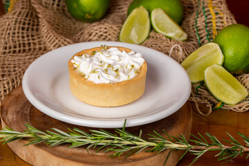 mini lemon pie topped with whipped cream and lemons in the background
