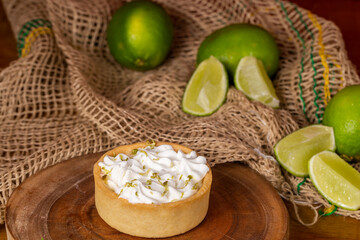 mini lemon pie topped with whipped cream and lemons in the background