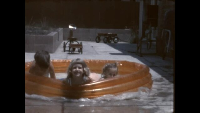 Playing in the Kiddie Pool 1962 - Siblings play in a kiddie pool at their home in Canoga Park, California in 1962. 