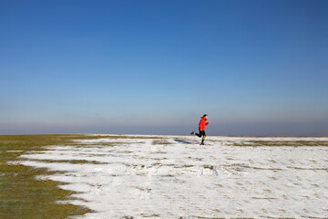 Obraz premium A man running in the mountains during the wintertime