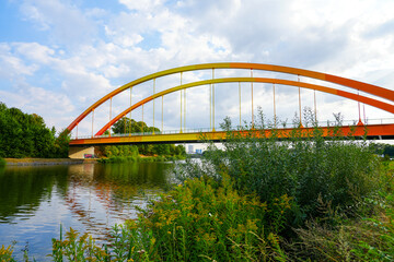 Fototapeta na wymiar Bridge Dattelner Meerbogen near Datteln on the canal. Arched bridge in bright colors on the Dattelner Meer. 