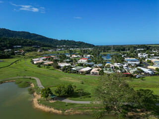 Fototapeta na wymiar Aerial view of tropical housing estate with mountains, blue sky and a lake
