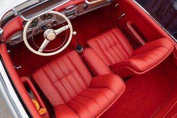 Interior of a classic vintage car, red leather.