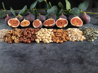 Mixed nuts, seeds, figs, eucalyptus branch. Background with healthy snack. Food background with copy space for text