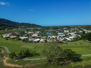 Fototapeta na wymiar Aerial view of tropical housing estate with mountains, blue sky and a lake